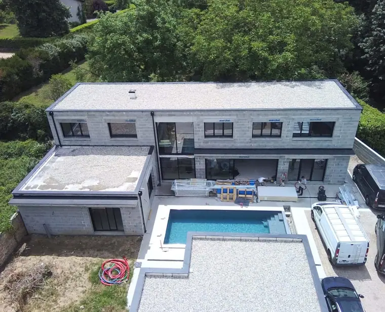 Maison achevée avec toiture-terrasse, grandes baies et piscine